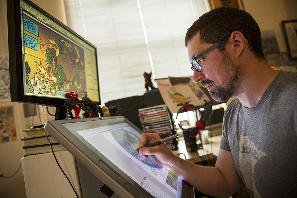 Zander Cannon using a stylus on a touch screen to color a panel 