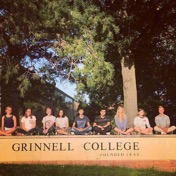 Group of friends by the Grinnell College sign on Park street