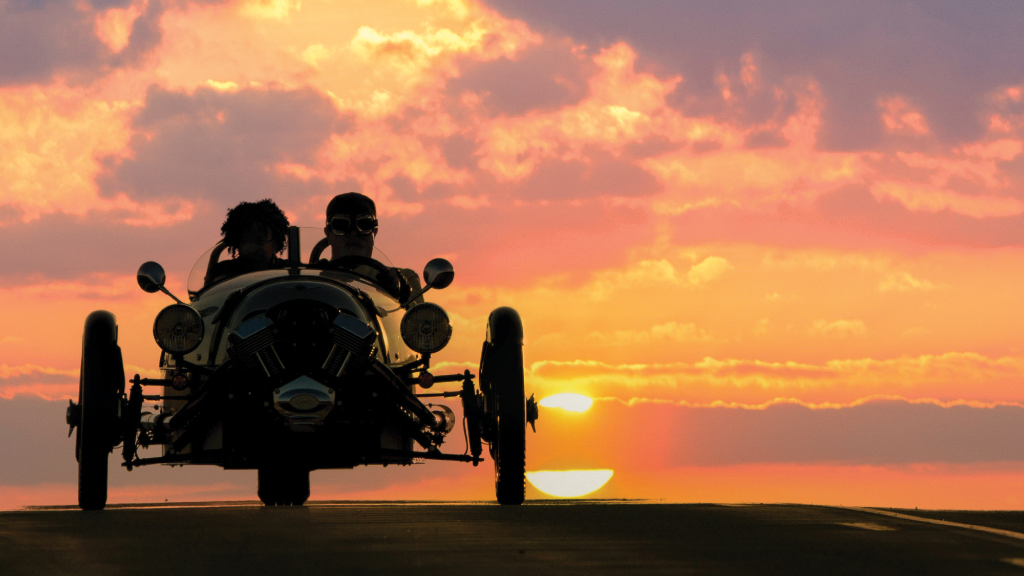 Scott and Freeman ride in his car silhouette by the setting sun