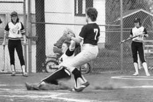Black and white photo of a Grinnell softball player sliding into base