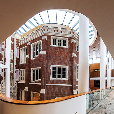 view of exterior brick work exposed to interior atrium from an elevated walkway