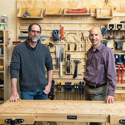 Monty Roper and Jeff Blanchard with tools hung on the wall in the background