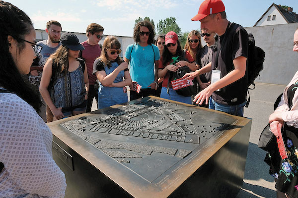 Students at the Sachsenhausen concentration camp memorial look at a model of the camp.