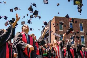 Graduates toss mortar boards in the air