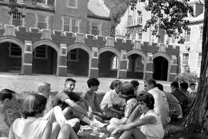 Black and white photo of student picnic under a tree on Mac field