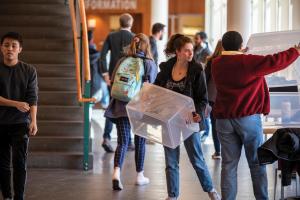 Students pick up totes to pack their belongings before leaving campus.