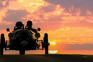 Scott and Freeman ride in his car silhouette by the setting sun