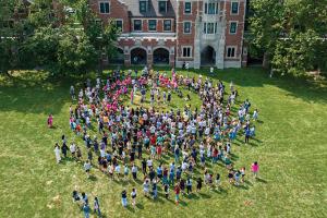 An aerial photo shows the incoming class gatherd on Mac Field in front of Gates Tower